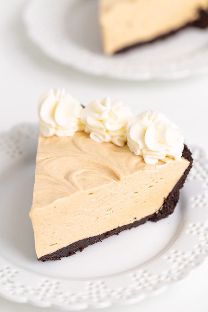 A slice of peanut butter pie on a plate with a white background