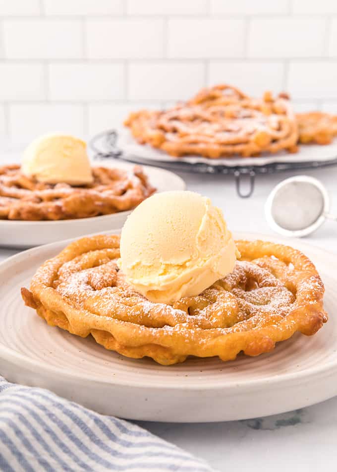 Homemade Funnel Cakes topped with powdered sugar.