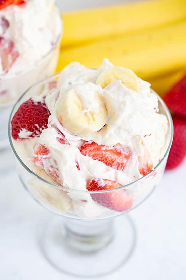 A bowl of strawberry banana ice cream with a strawberry banana cheesecake salad topping.