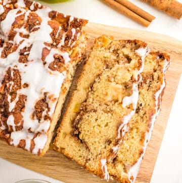 A slice of apple cinnamon bread on a cutting board.