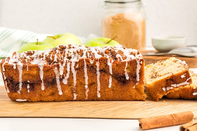 A delicious slice of apple cinnamon bread on a cutting board.