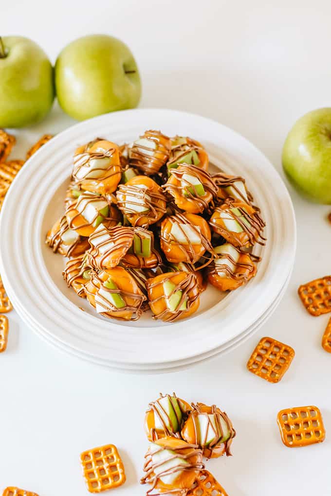 A plate of caramel apple bites, including apples and pretzels.