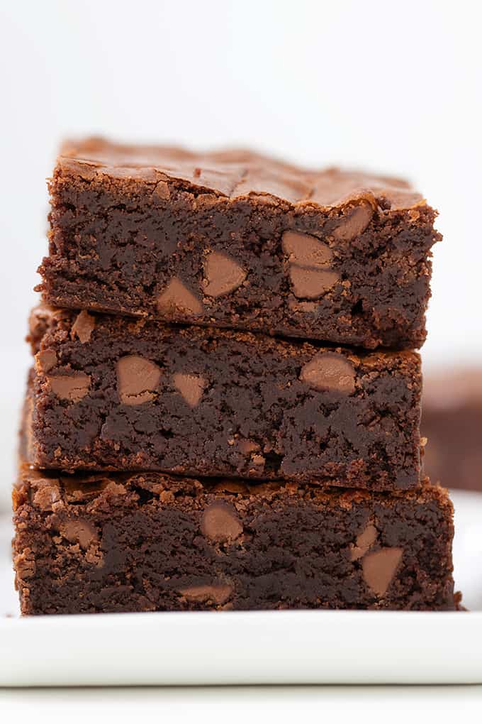 A stack of irresistible chocolate brownies on a sleek white plate, making classic box brownies unforgettable.