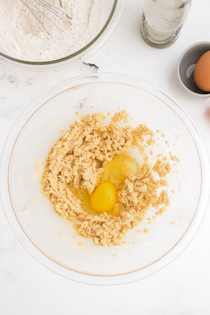 A bowl with flour, eggs, and apple cinnamon bread ingredients.