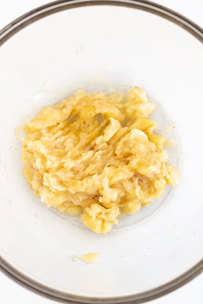 A bowl of mashed bananas in a white bowl.