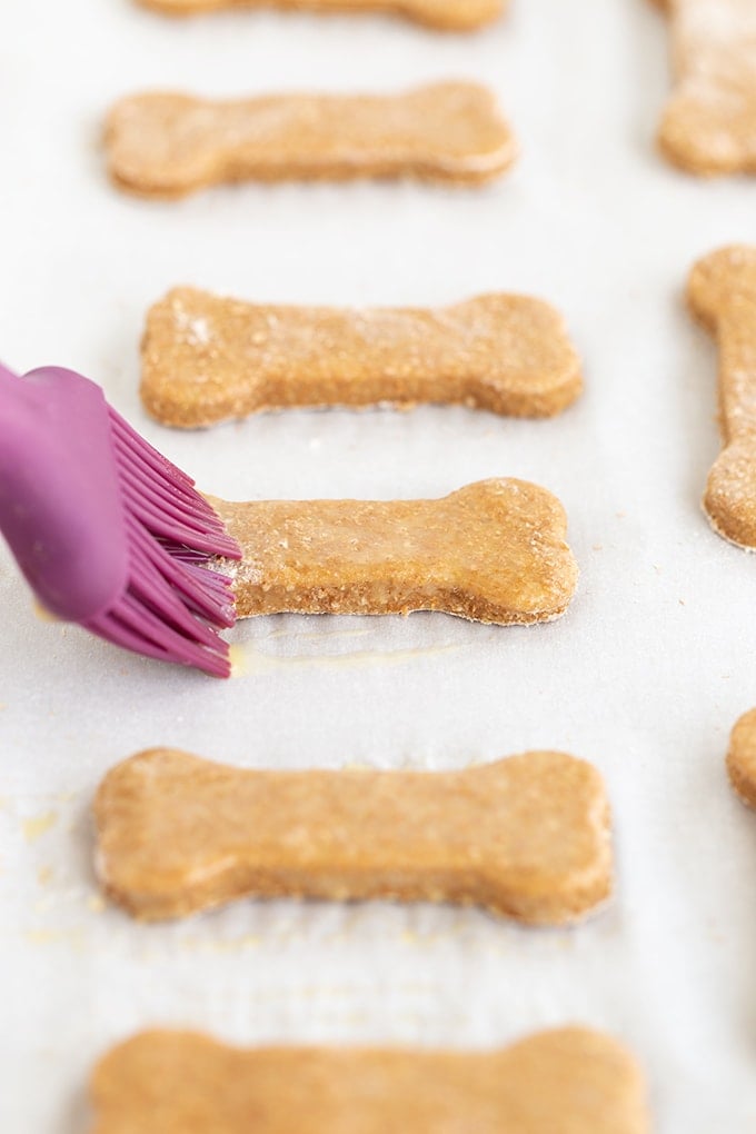 A purple utensil is being used to make dog biscuits.