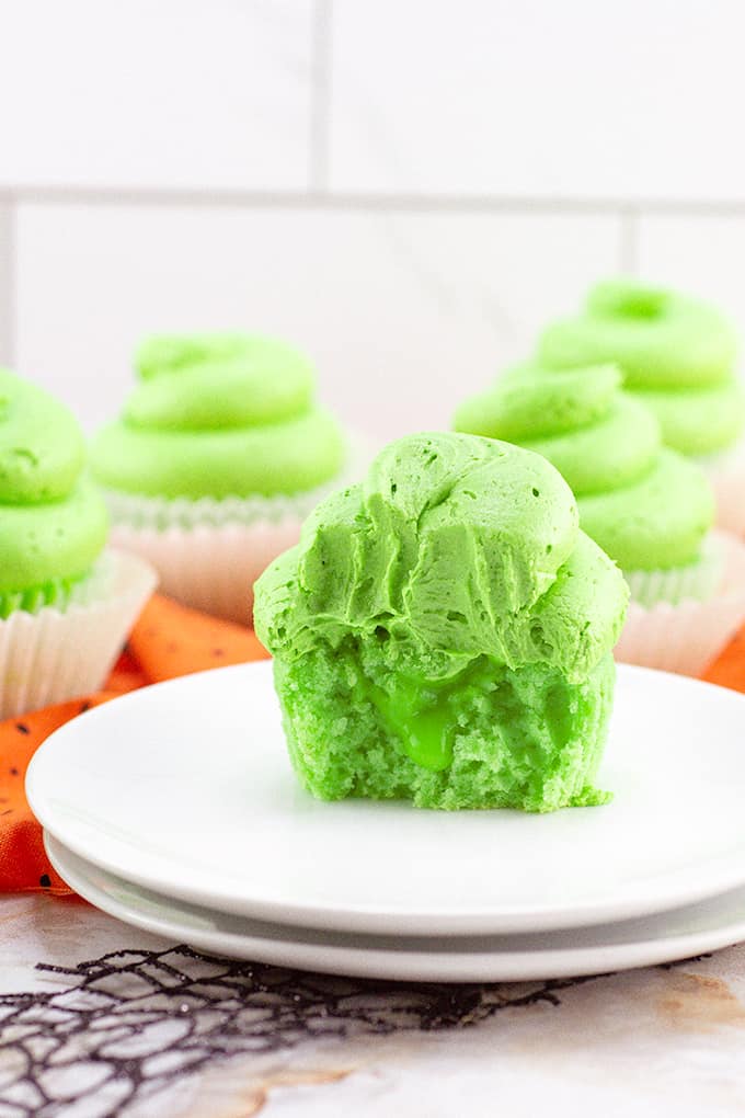 A white plate of lime cupcakes showing the lime curd oozing out