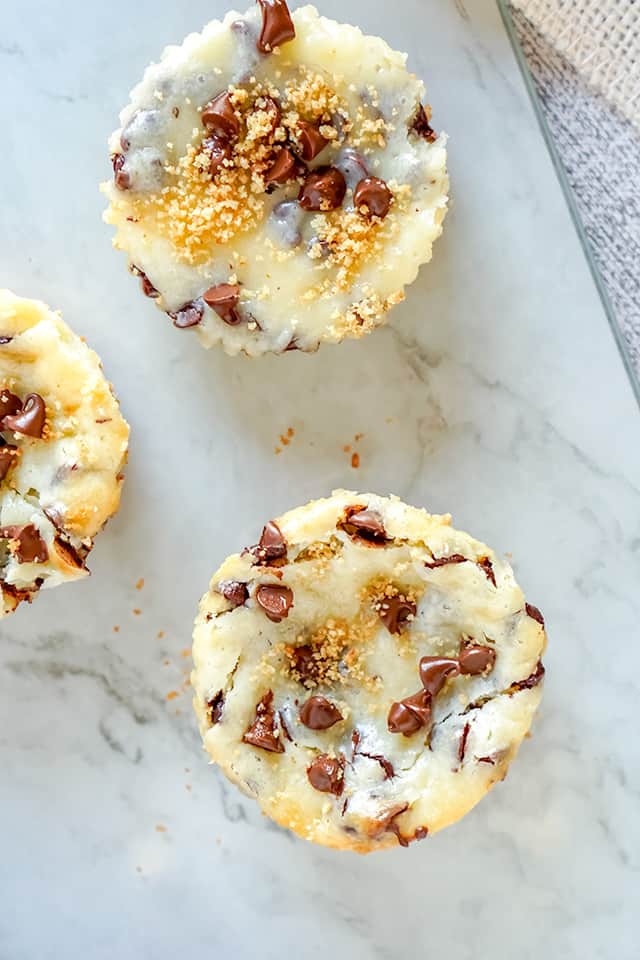 overhead of three mini chocolate cheesecakes on marble background