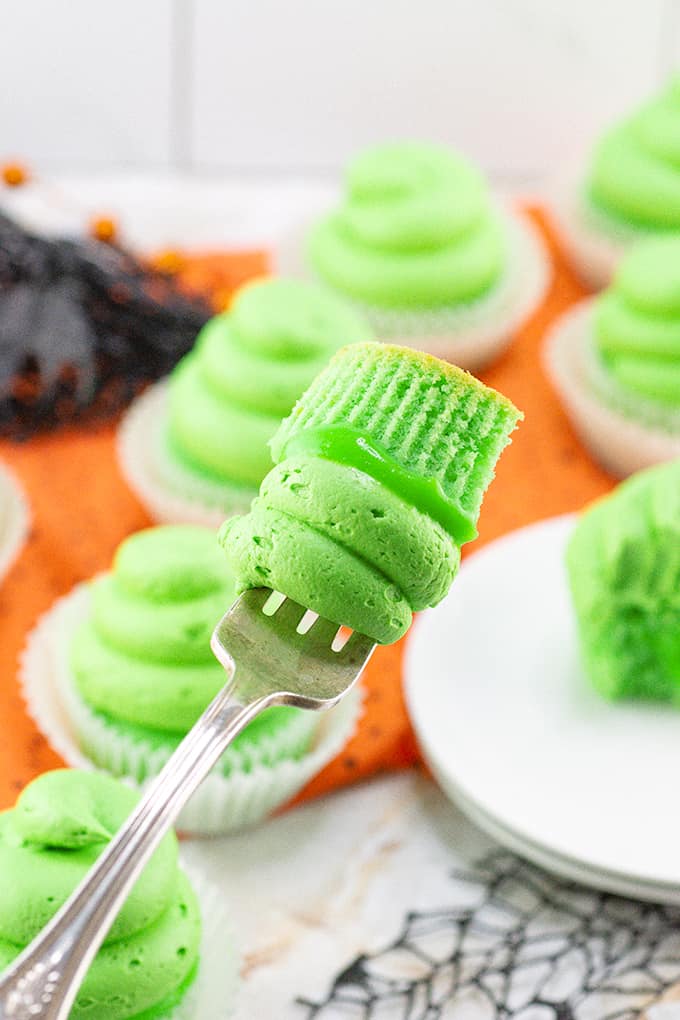 A fork is being used to pick up a Lime cupcake.