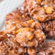 A plate of apple fritters on a white plate.
