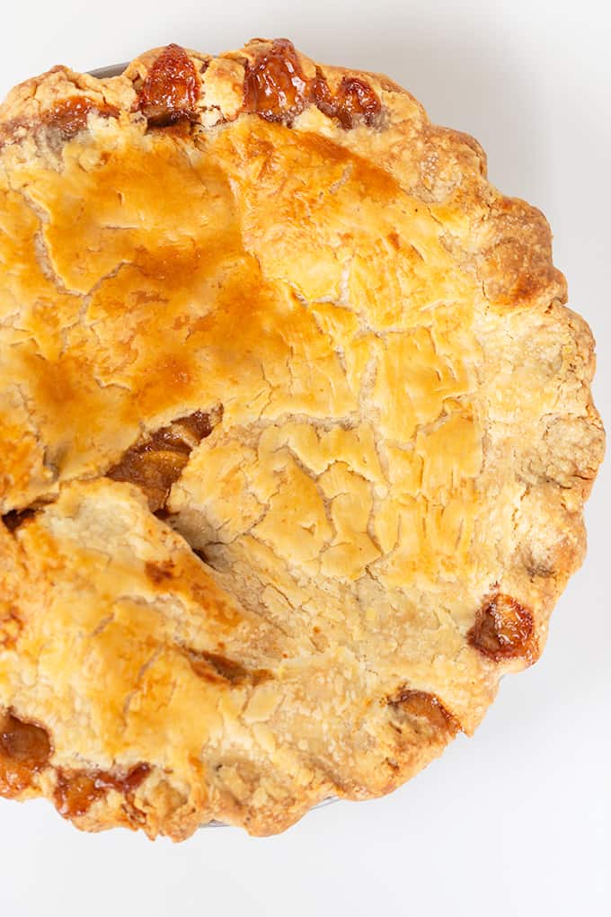 photo from above of baked apple pie on a white background