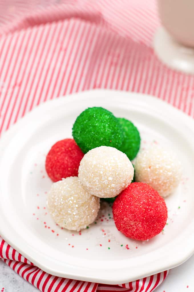 Christmas truffles on a white plate with a red and white striped linen