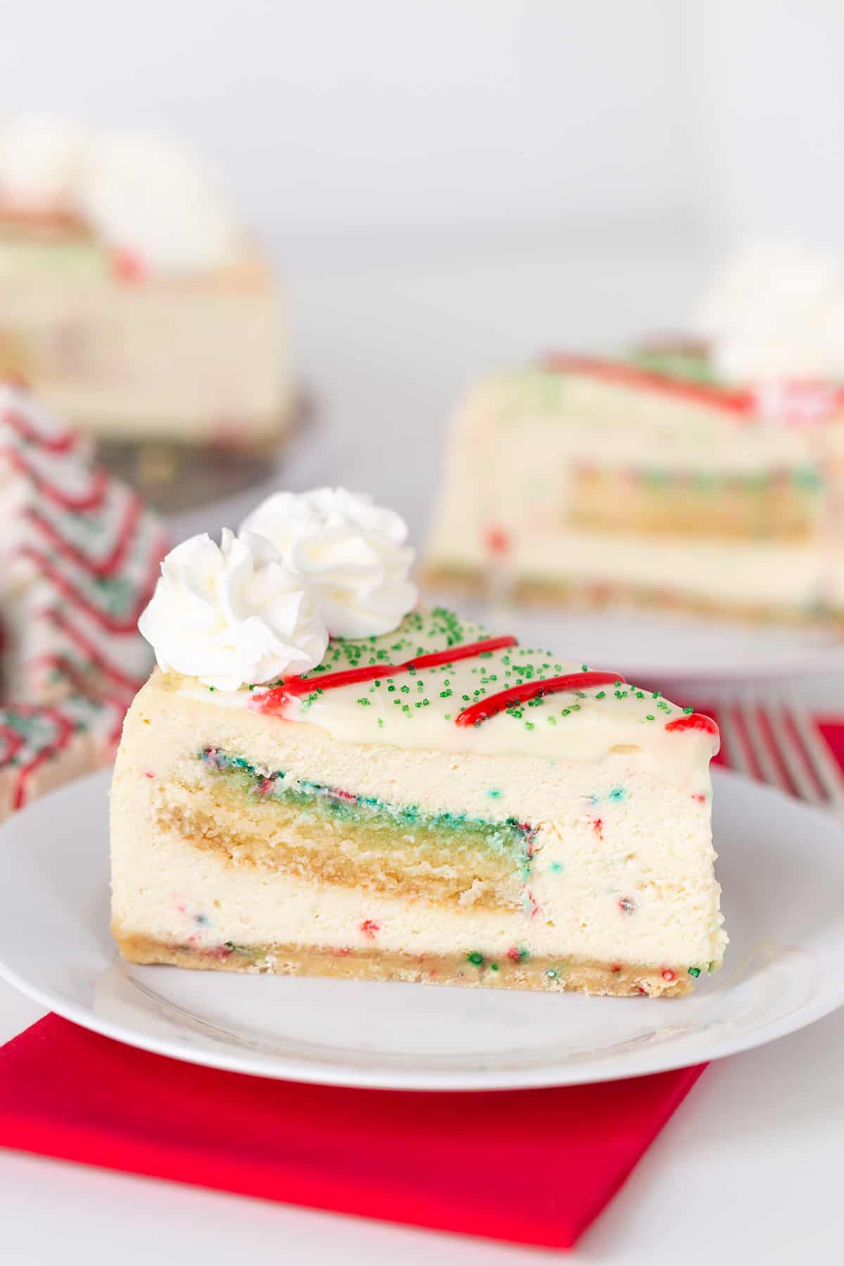 A slice of Christmas Tree Cheesecake, resembling a Little Debbie treat, on a white plate.