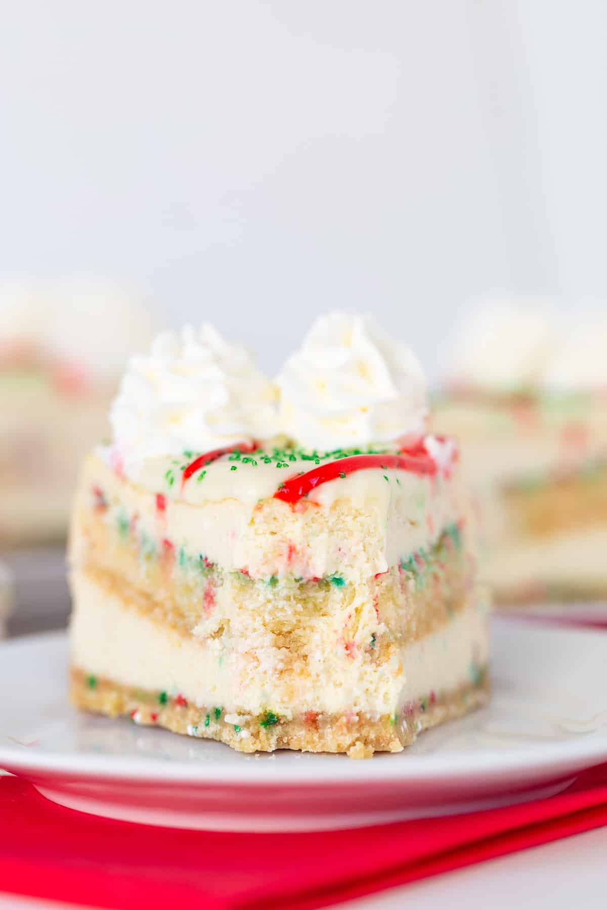 A slice of Christmas cake on a plate decorated with a Christmas tree.