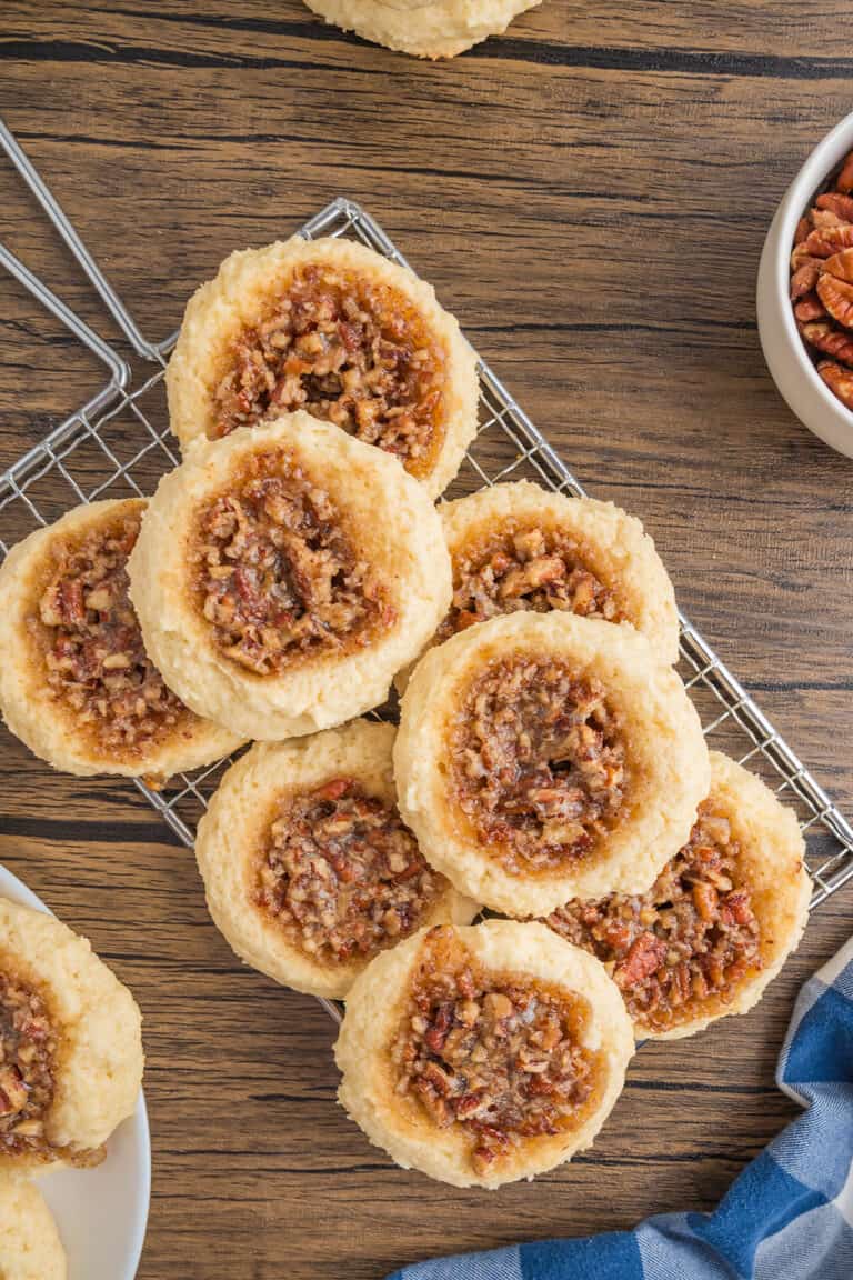Pecan Pie Cookies on a rack next to a bowl of pecans.