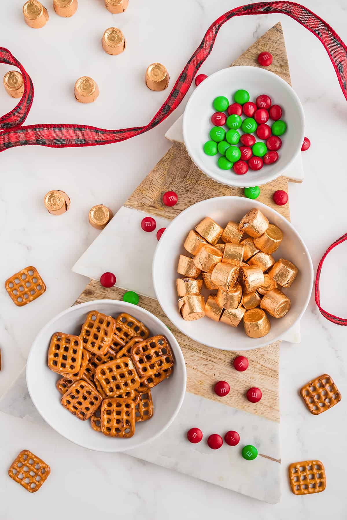 Modified Description: Three bowls of pretzels and candy canes, surrounded by a Christmas tree.
