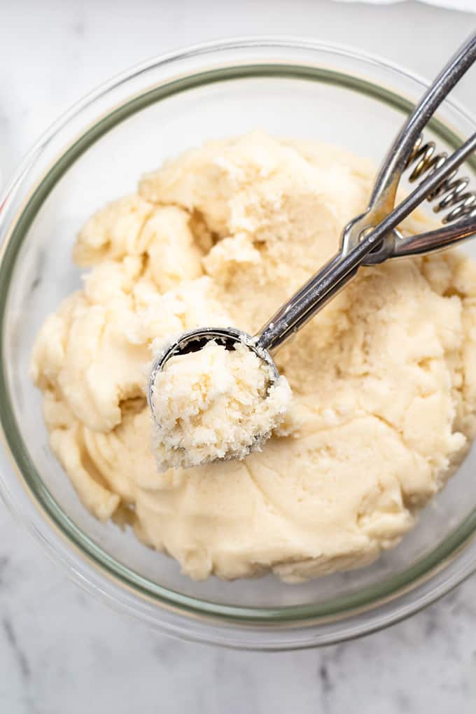 A bowl of whipped cream with a whisk in it, perfect for topping Christmas desserts like truffles.