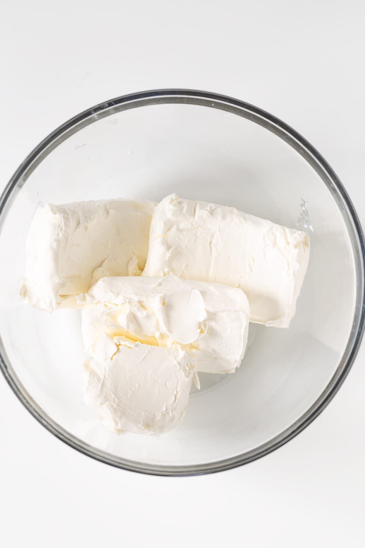 Whipped cream in a glass bowl on a white background, perfect for your Christmas Tree Cheesecake.