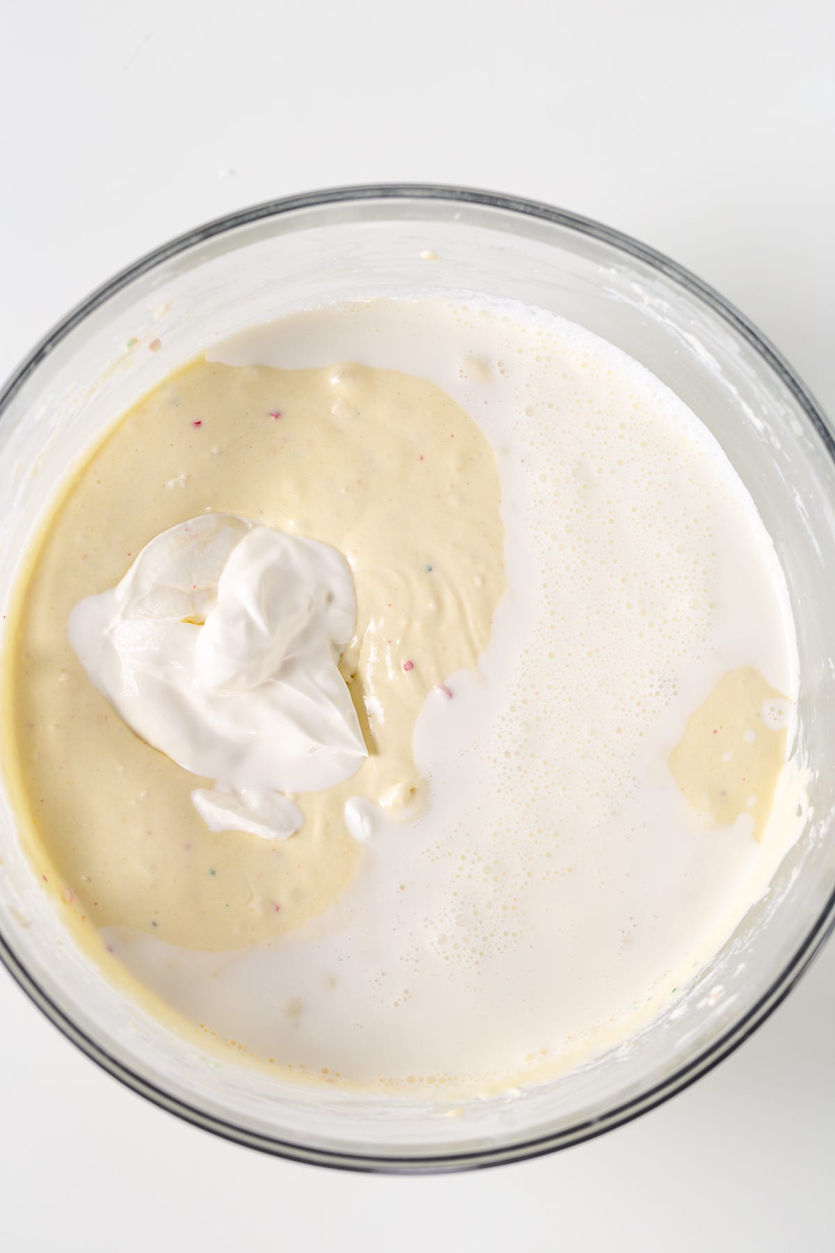 A bowl filled with whipped cream and icing, resembling a Christmas Tree Cheesecake.