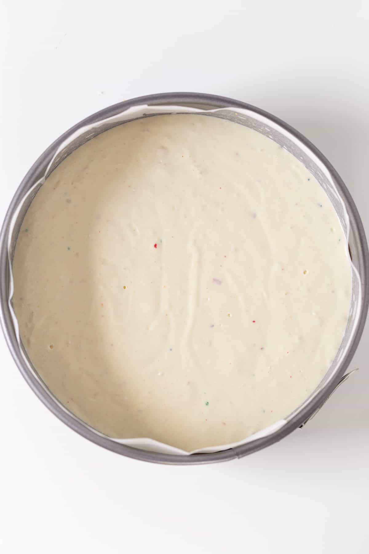 Cheesecake batter in a pan on a white background.