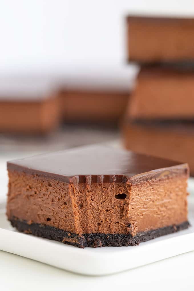 A decadent slice of chocolate cheesecake on a white plate.