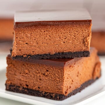 A stack of chocolate cheesecake bars on a white plate.