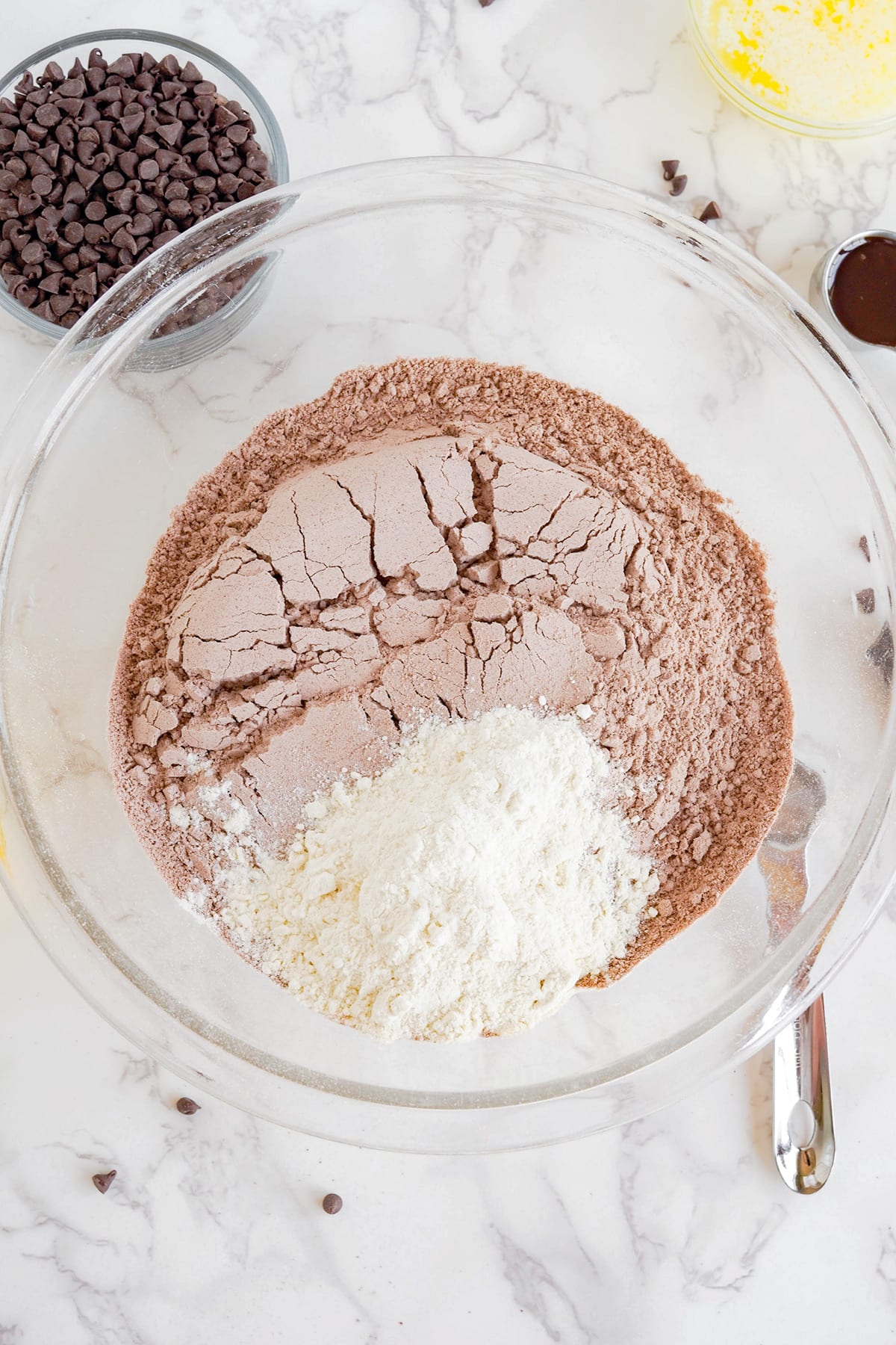 Brownie mix and chocolate chip cookie dough in a glass bowl.