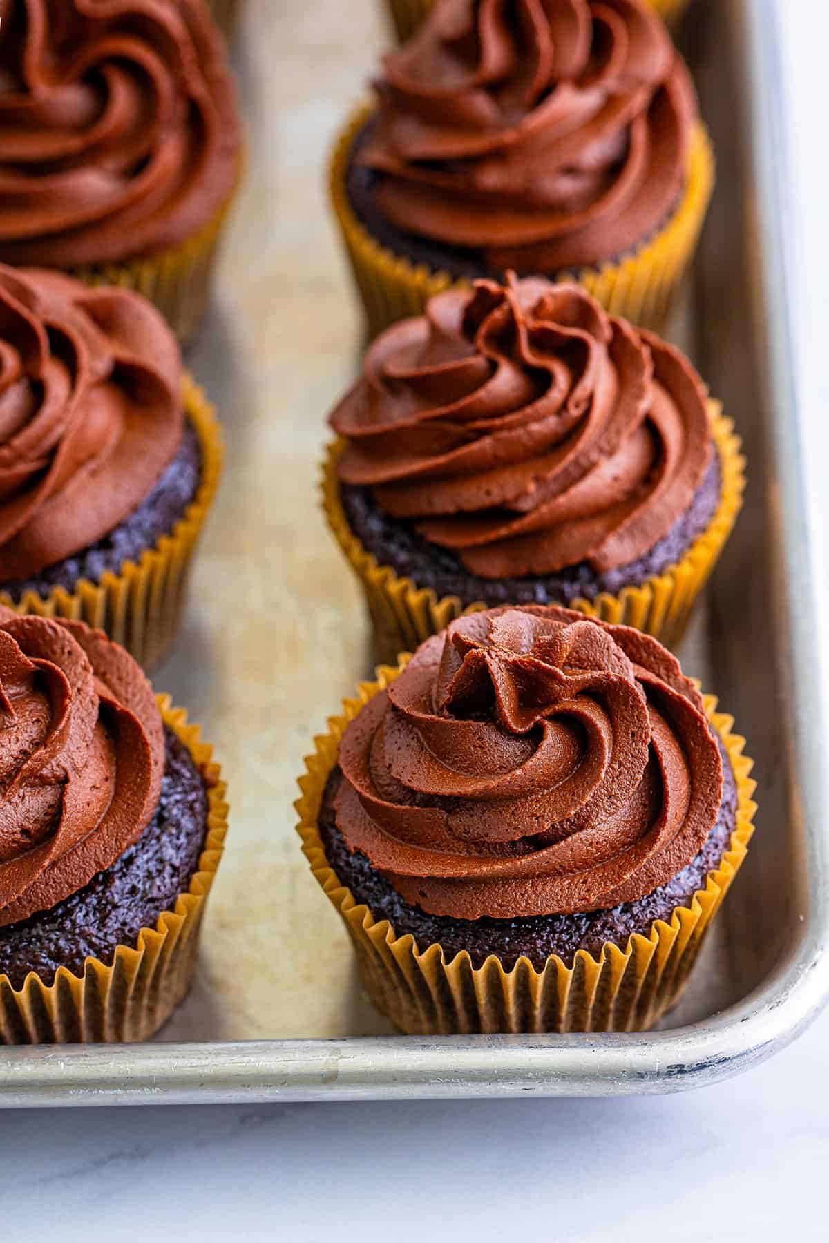 A tray of Baileys chocolate cupcakes with swirled chocolate frosting.