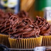Chocolate cupcakes with swirls of Baileys frosting and chocolate chips on top.
