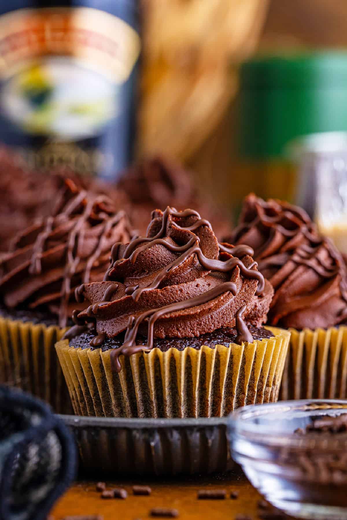 Chocolate cupcakes with swirls of Baileys frosting and chocolate chips on top.