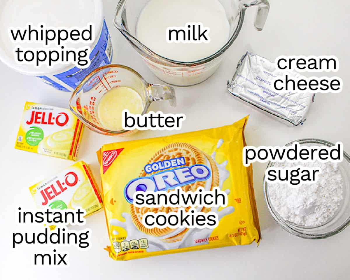 Ingredients for a lemon delight recipe displayed: milk, whipped topping, cream cheese, butter, instant pudding mix, golden oreo cookies, and powdered sugar.