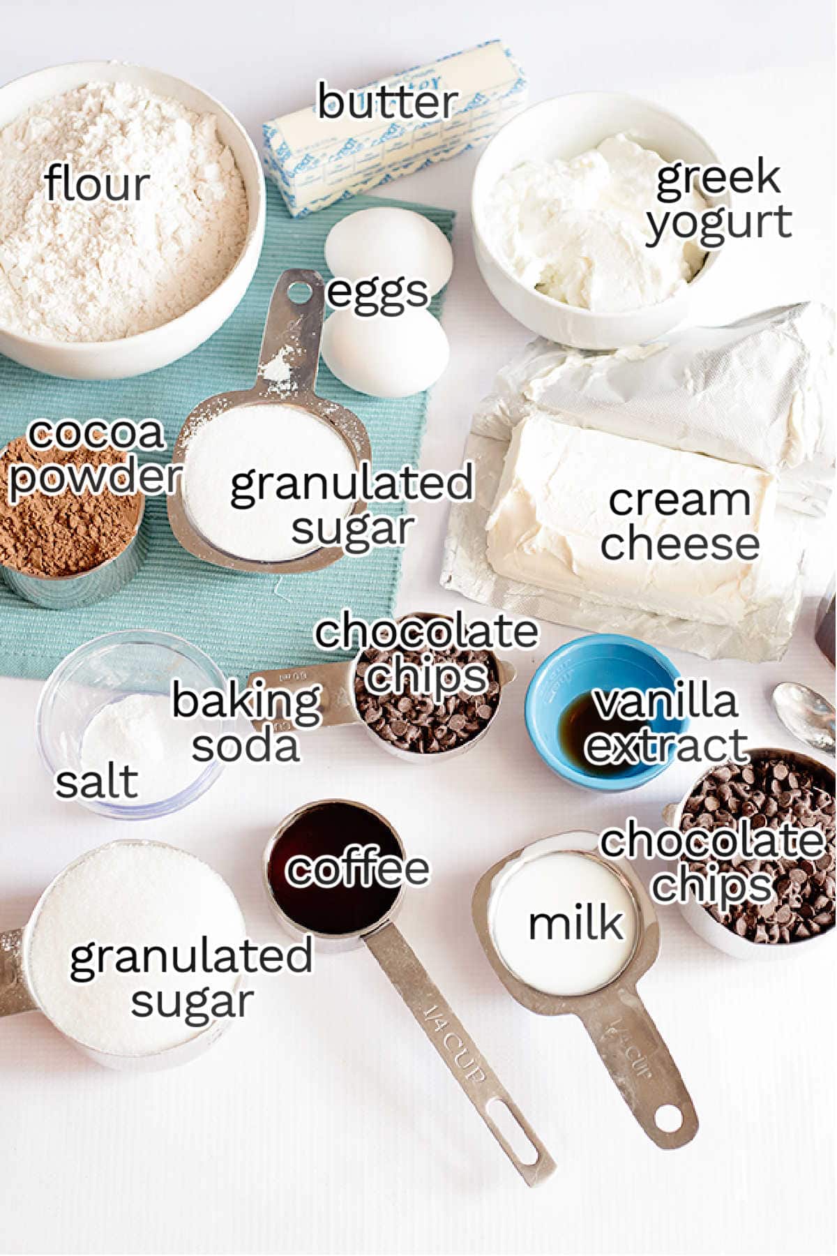 Ingredients for baking chocolate cheesecake muffins: flour, butter, eggs, Greek yogurt, cocoa powder, granulated sugar, cream cheese, chocolate chips, salt, baking soda, vanilla extract, coffee, and milk.