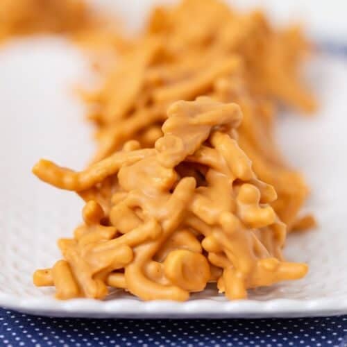 Close-up of No Bake Butterscotch Haystacks made with melted butterscotch chips and chow mein noodles, arranged on a white plate.