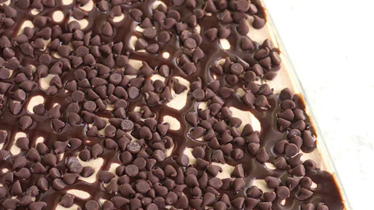 A close-up view of a decadent dessert topped with chocolate syrup and mini chocolate chips, perfect for fans of chocolate desserts.