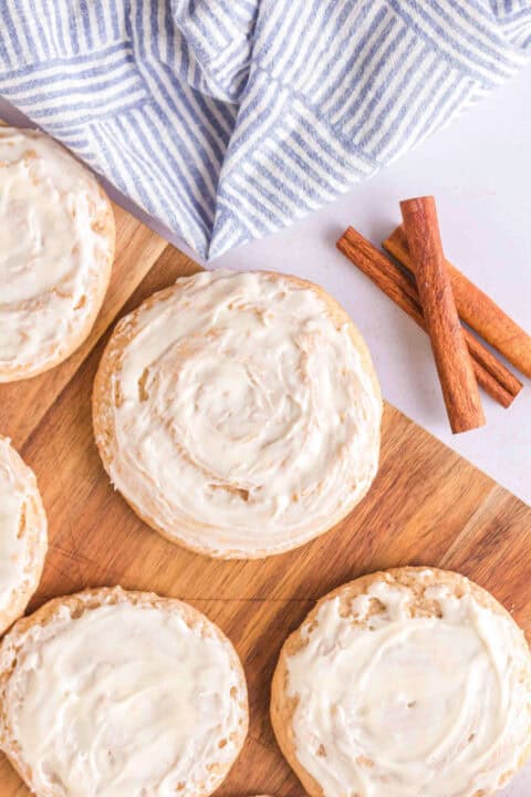 Honey Bun Cookies with sweet frosting are arranged on a wooden board.