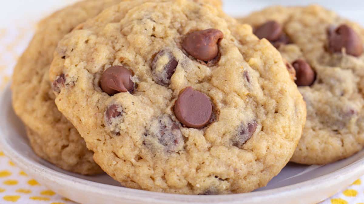 A close-up of several chocolate chip cookies on a white plate, perfect for anyone searching for easy cookie recipes using pantry staples.