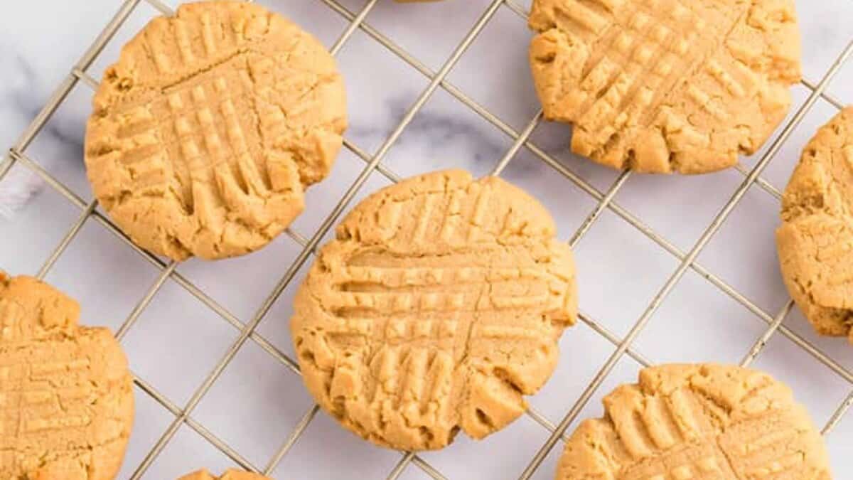 Peanut butter cookies with crisscross fork marks, made from pantry staples, are cooling on a wire rack.