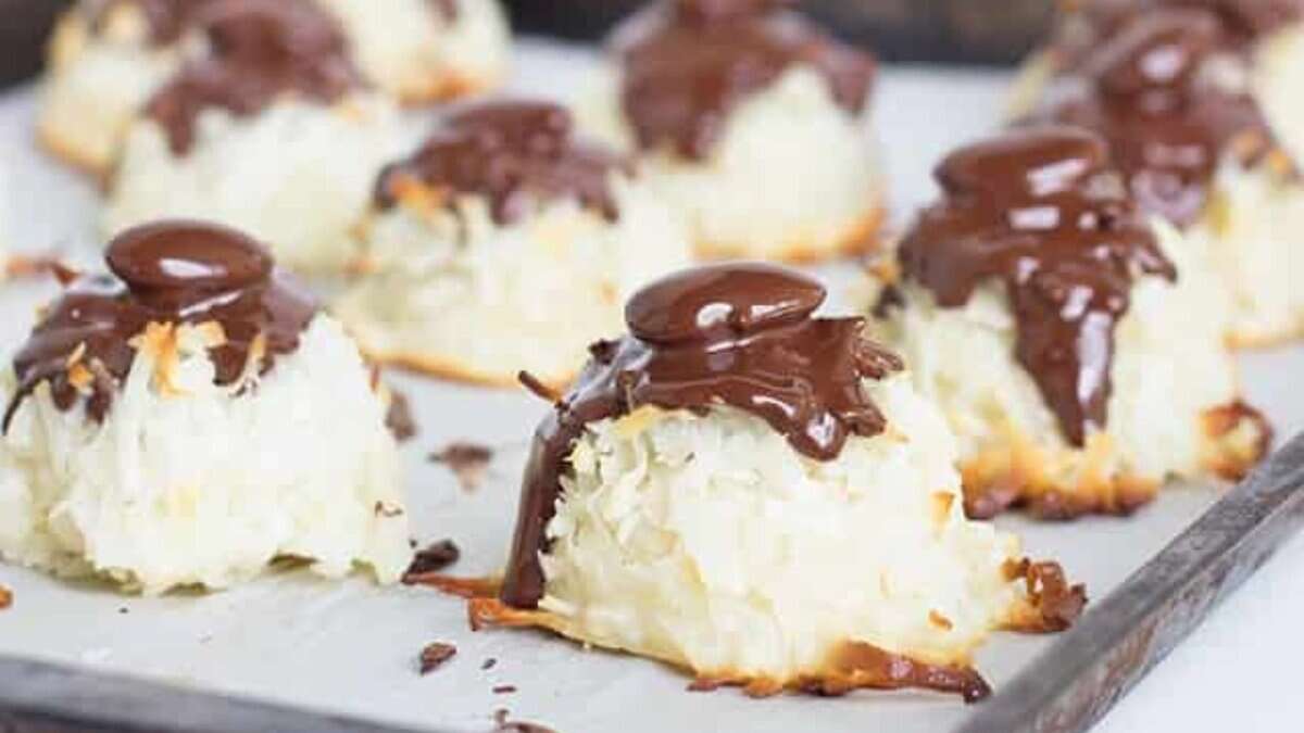 Coconut macaroons on a baking sheet, topped with melted chocolate&mdash;one of those easy cookie recipes made with pantry staples.
