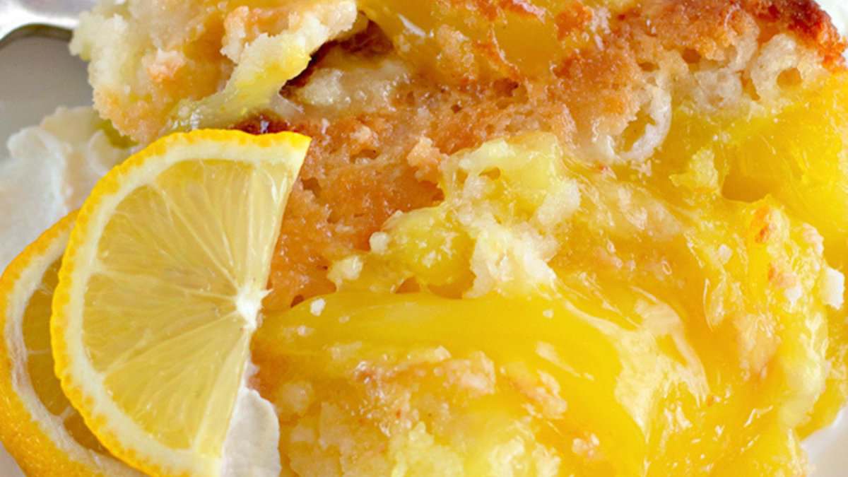 Close-up of a lemon dessert with a golden, crumbly topping, creamy yellow filling, and garnished with slices of fresh lemon—a perfect choice for those who love lemon desserts and spring desserts.