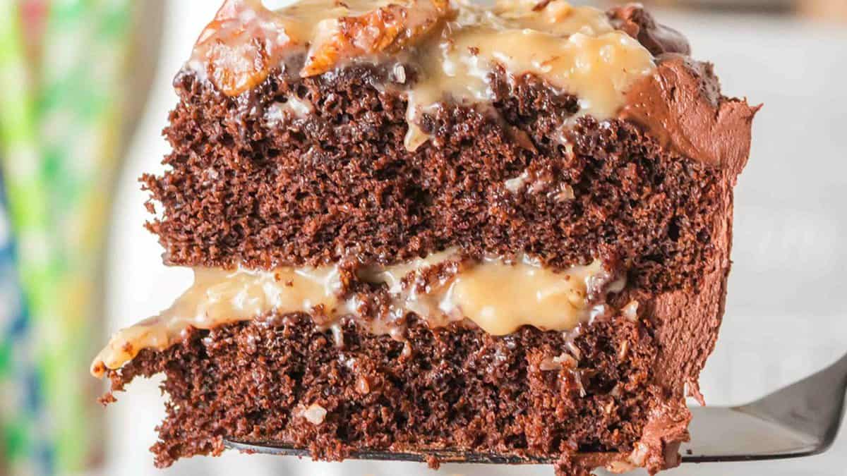 Close-up of a slice of chocolate cake with two layers, chocolate frosting, and a creamy filling in between&mdash;perfect for Easter desserts or holiday desserts.