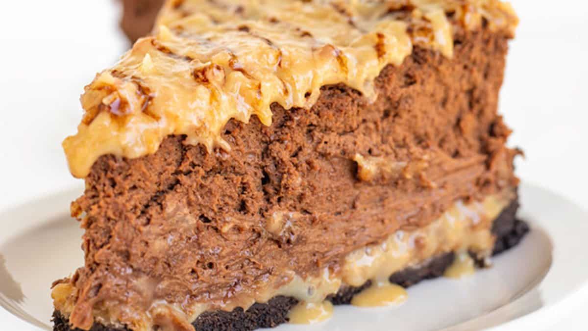 A slice of chocolate cheesecake with a chocolate crust and creamy topping on a white plate&mdash;perfect for holiday desserts or as a sweet addition to your Easter desserts spread.