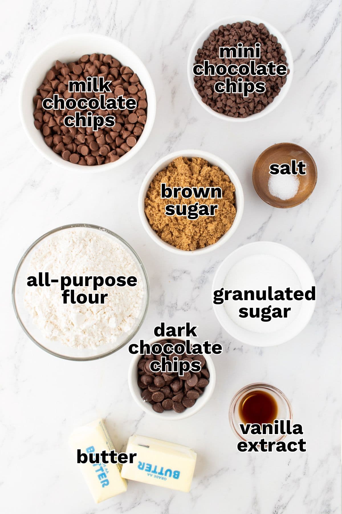 Bowls containing ingredients like milk chocolate chips, brown sugar, and butter are ready to create irresistible Cookie Dough Truffles on a marble surface.