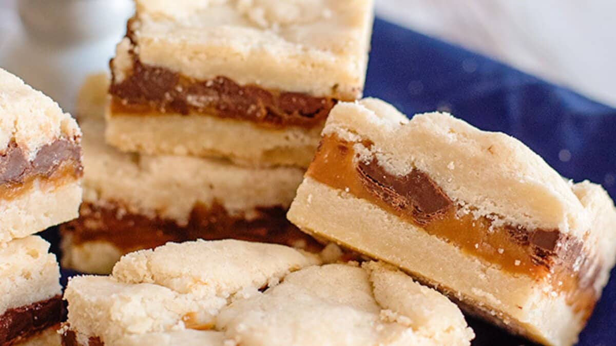 Close-up of stacked shortbread bars with layers of caramel and chocolate filling&mdash;perfect for anyone seeking easy desserts that impress with minimal effort.