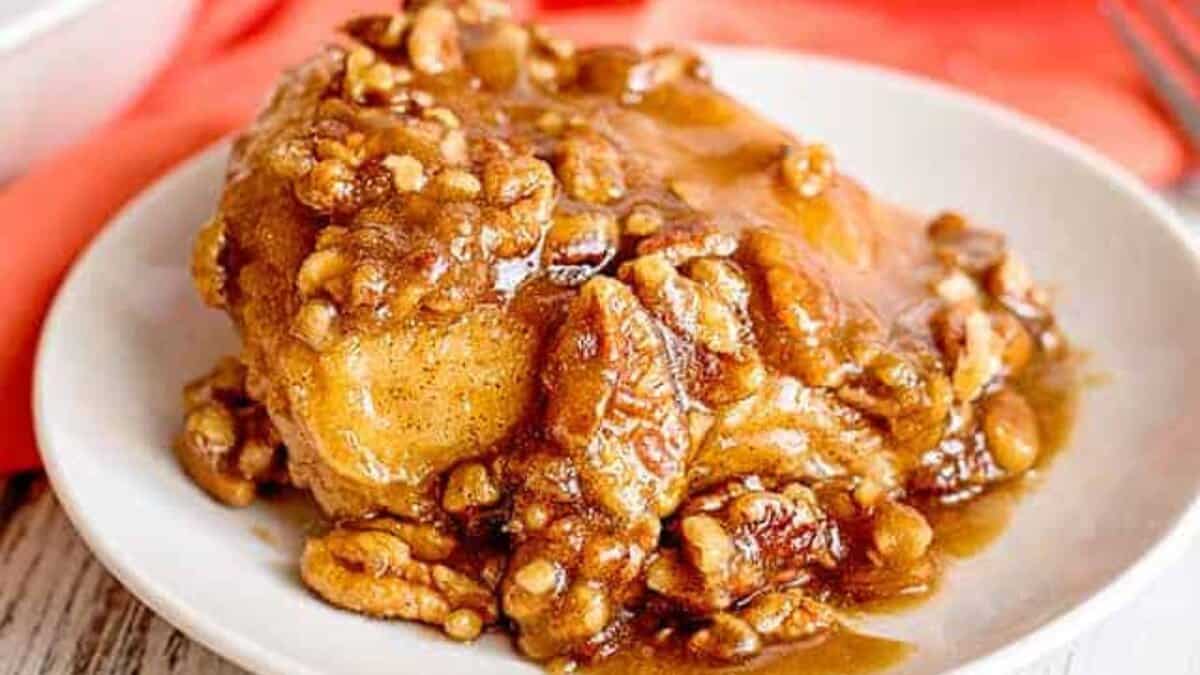 A serving of baked chicken covered in a caramelized brown sugar sauce with chopped walnuts, presented on a white plate&mdash;perfect for those seeking stress-free desserts anyone can make.
