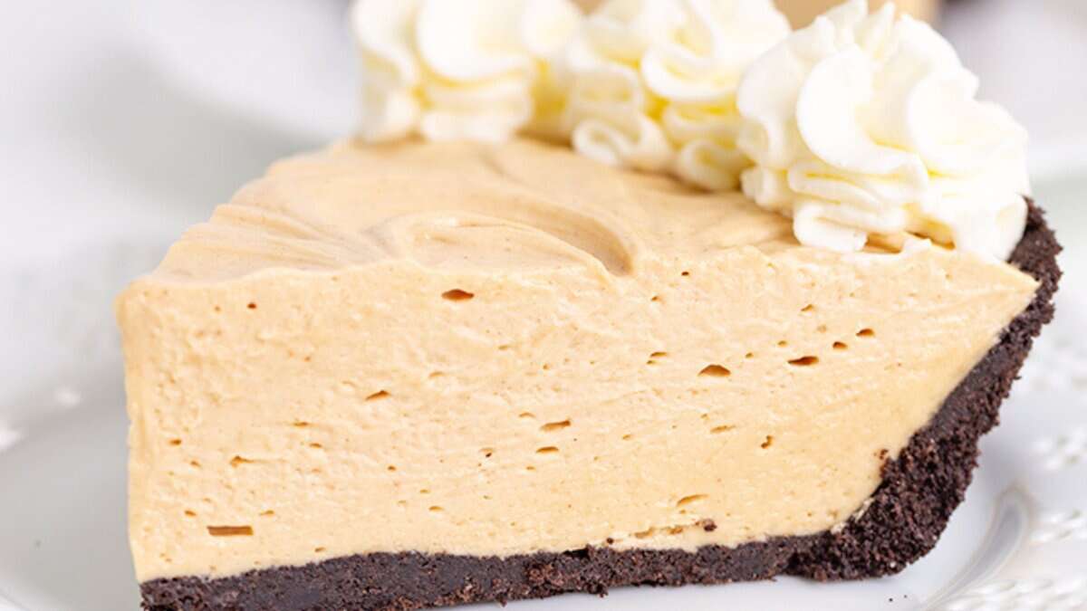 A slice of creamy peanut butter pie with a chocolate cookie crust, topped with swirls of whipped cream&mdash;one of those classic desserts everyone loves.