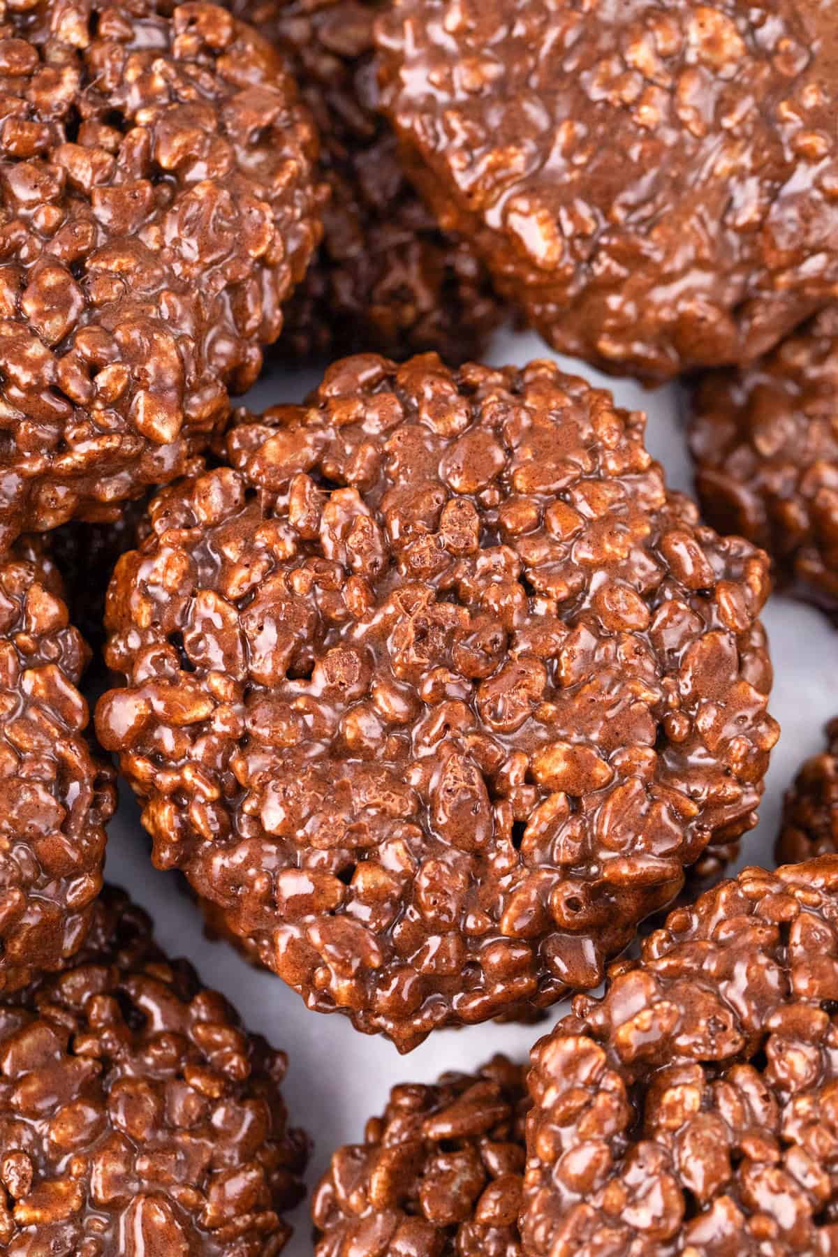 Close-up of several no-bake chocolate oatmeal cookies stacked together, their textured, glossy surface resembling classic Star Crunch Cookies.