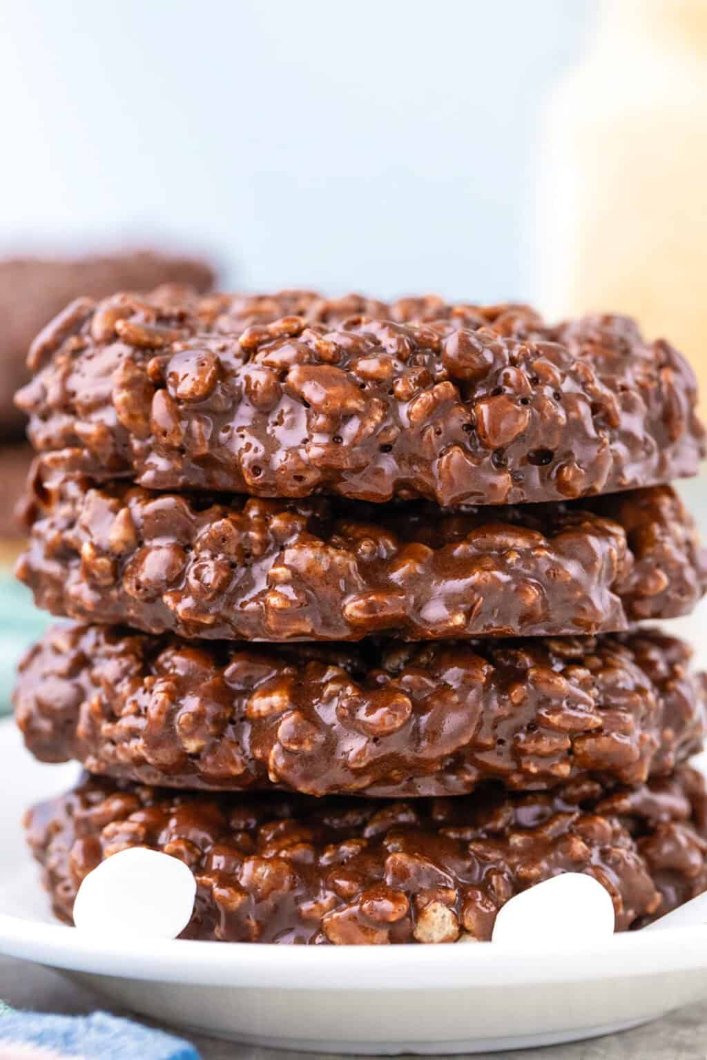 A stack of four Star Crunch Cookies sits on a white plate, with a few mini marshmallows nearby.