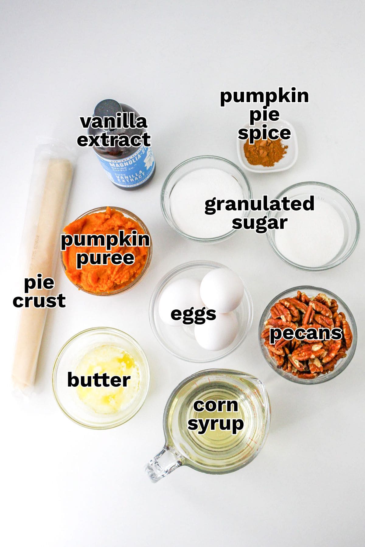 Top-down view of labeled ingredients for pie, including pie crust, vanilla extract, pumpkin pie spice, granulated sugar, pumpkin puree, eggs, pecans, butter, and corn syrup on a white background—everything you need to make the perfect Pumpkin Pecan Pie.