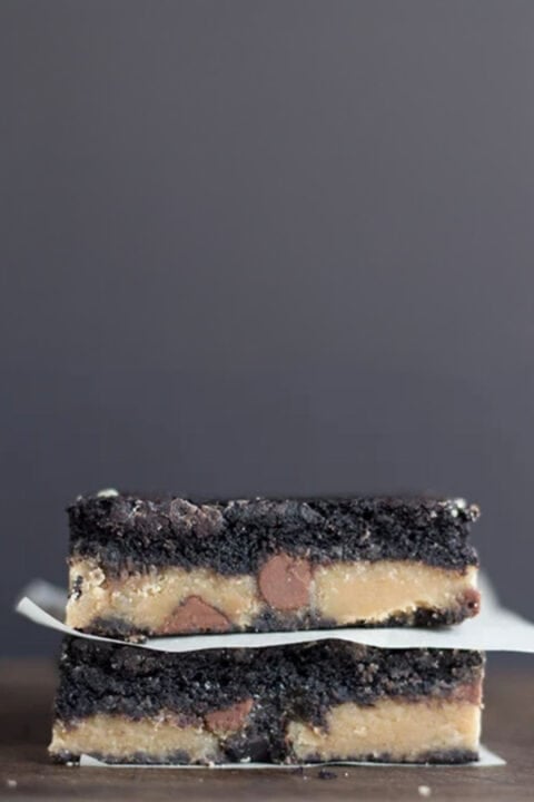 Two stacked peanut butter brownies with a layer of peanut butter and chocolate chips in the center.