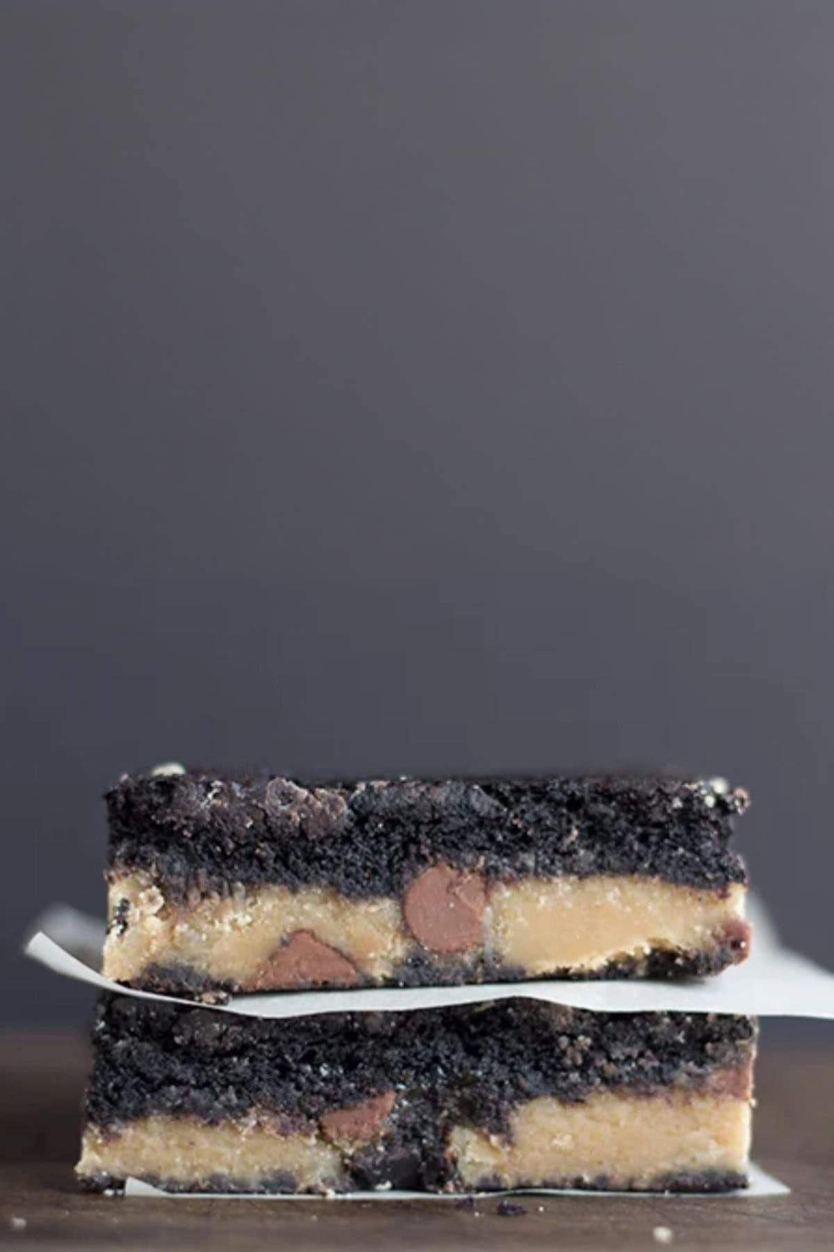 Two stacked peanut butter brownies with a layer of peanut butter and chocolate chips in the center.